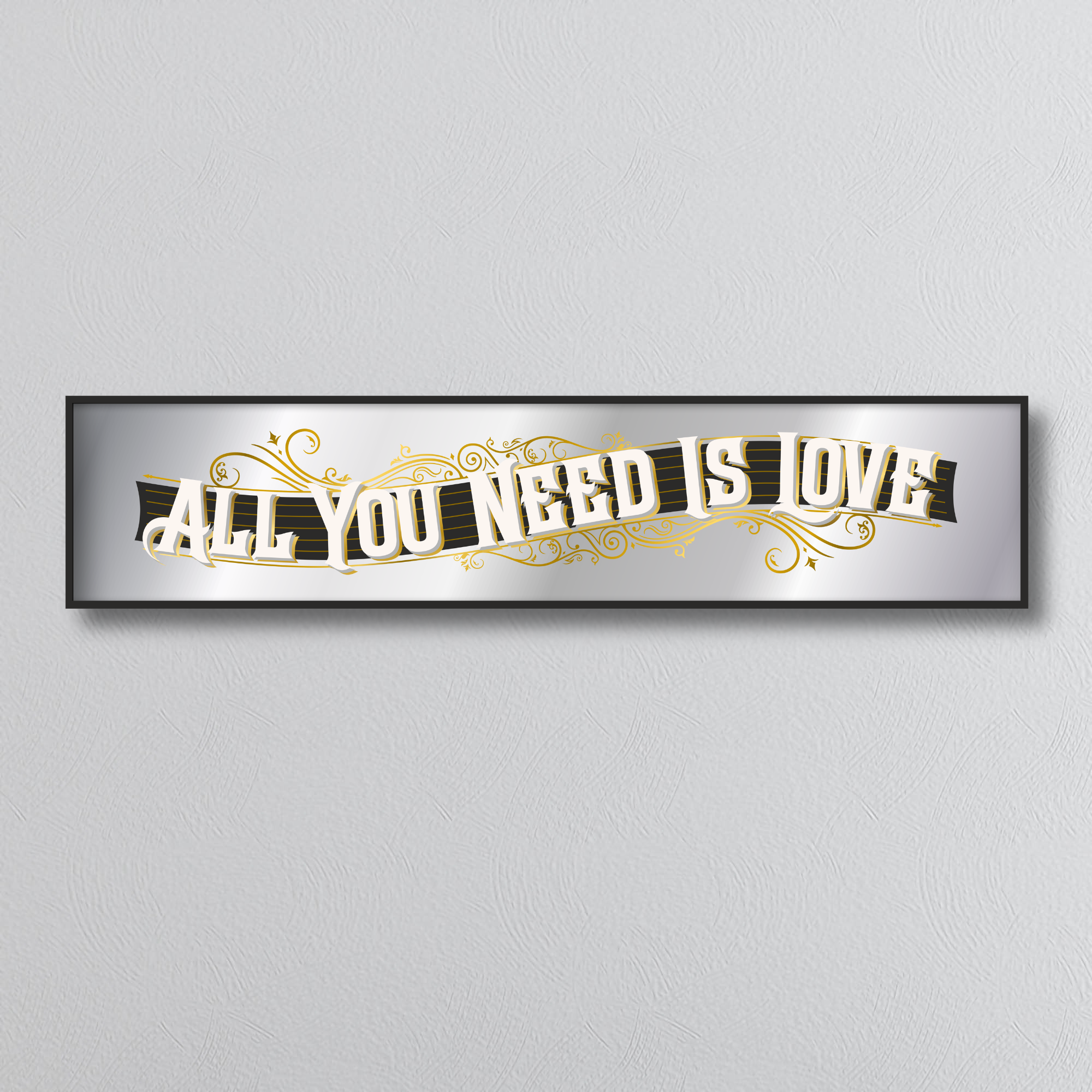 Decorative mirror sign with 'All You Need Is Love' art deco style text on a gray background