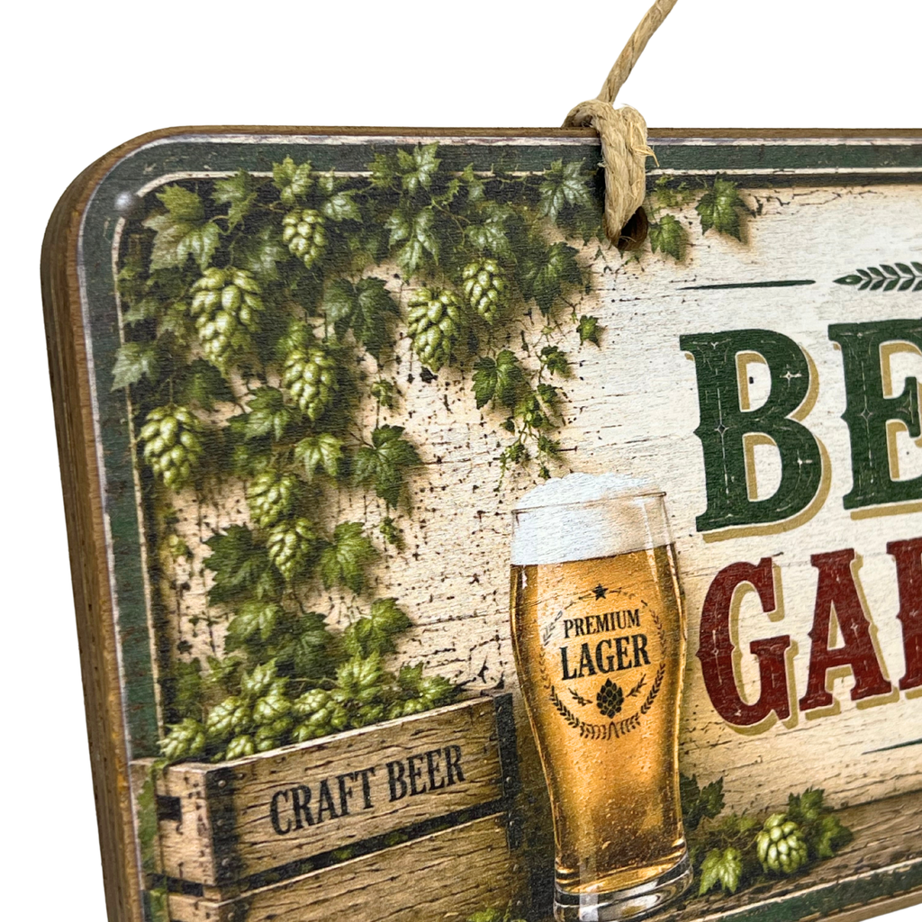 A rustic decorative beer-themed sign with a hanging rope, featuring green hops vines, a glass of craft beer labeled 'Premium Lager,' and partial text reading 'BEER' and 'GARDEN.'.