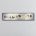Decorative mirror sign with 'Cocktail Lounge' art deco style text on a light gray background