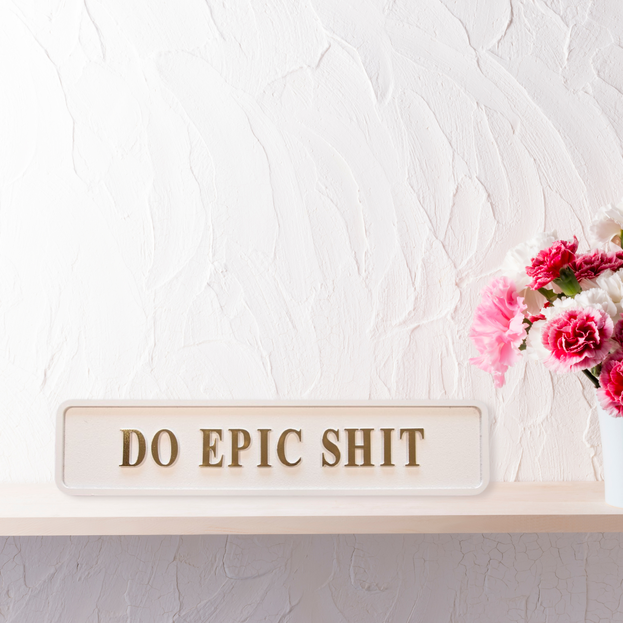Cream and gold foiled street sign with "do epic shit" lettering