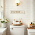 Stylish bathroom with cream and gold sign saying 'ENJOY YOUR POO'