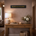 Living room with wooden console table, lamp, and decorative items against a wall with 'FANFUCKINTASTIC' sign.