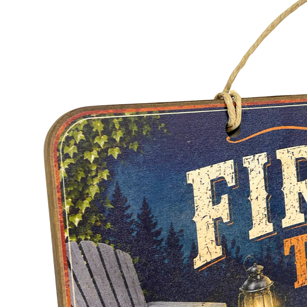 Close-up of a decorative hanging sign with a rustic printed design, showing part of the text 'FIR.
