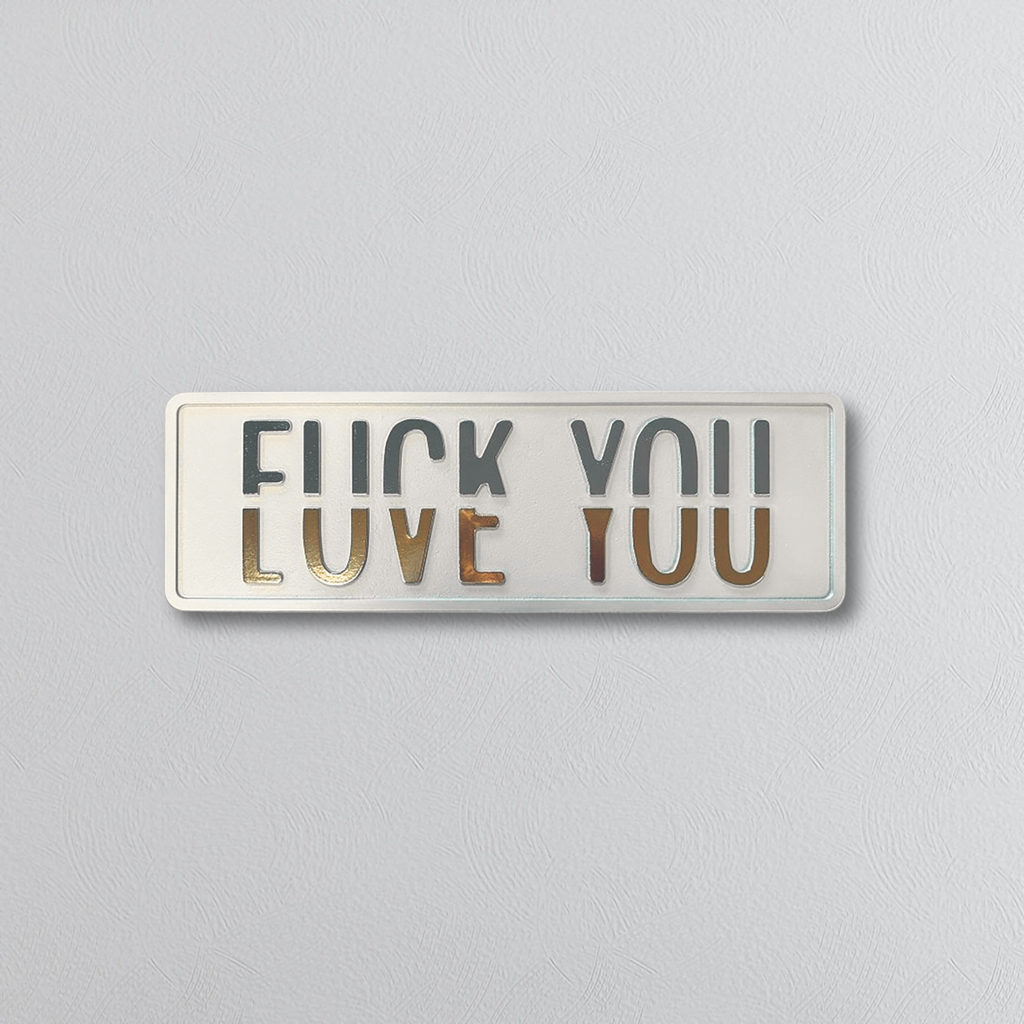 Decorative rectangluar sign with text split horizontally, the top saying FUCK YOU and the bottom LOVE YOU