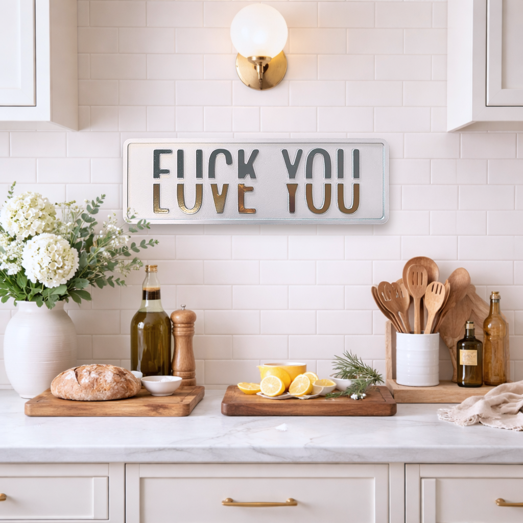 Modern kitchen with white countertops, wooden utensils, and a decorative sign saying FUCK YOU LOVE YOU.