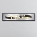 Decorative mirror sign with 'I Love Us' art deco style text on a plain background