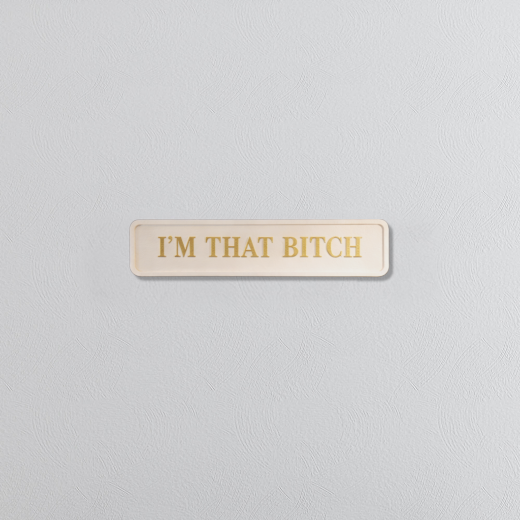 Rectangular sign with 'I'M THAT BITCH' in gold text on a light gray background