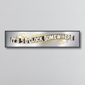 Decorative mirror sign with 'It's 5 o'clock somewhere' art deco style text on a light gray background