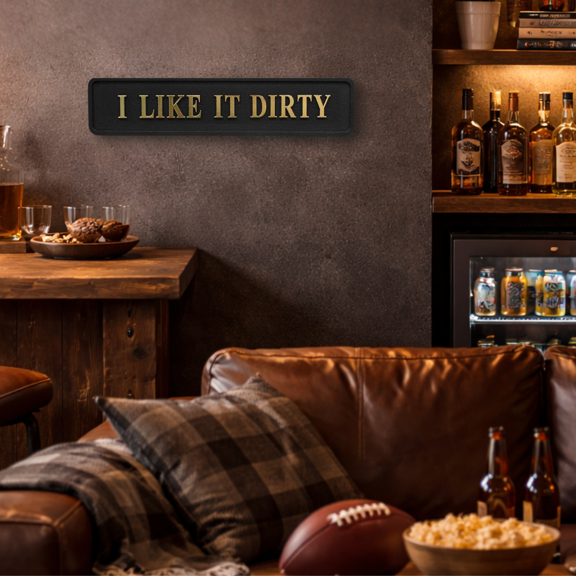 Cozy man cave room with a brown leather couch, beer bottles and 'I Like It Dirty' sign on the wall.