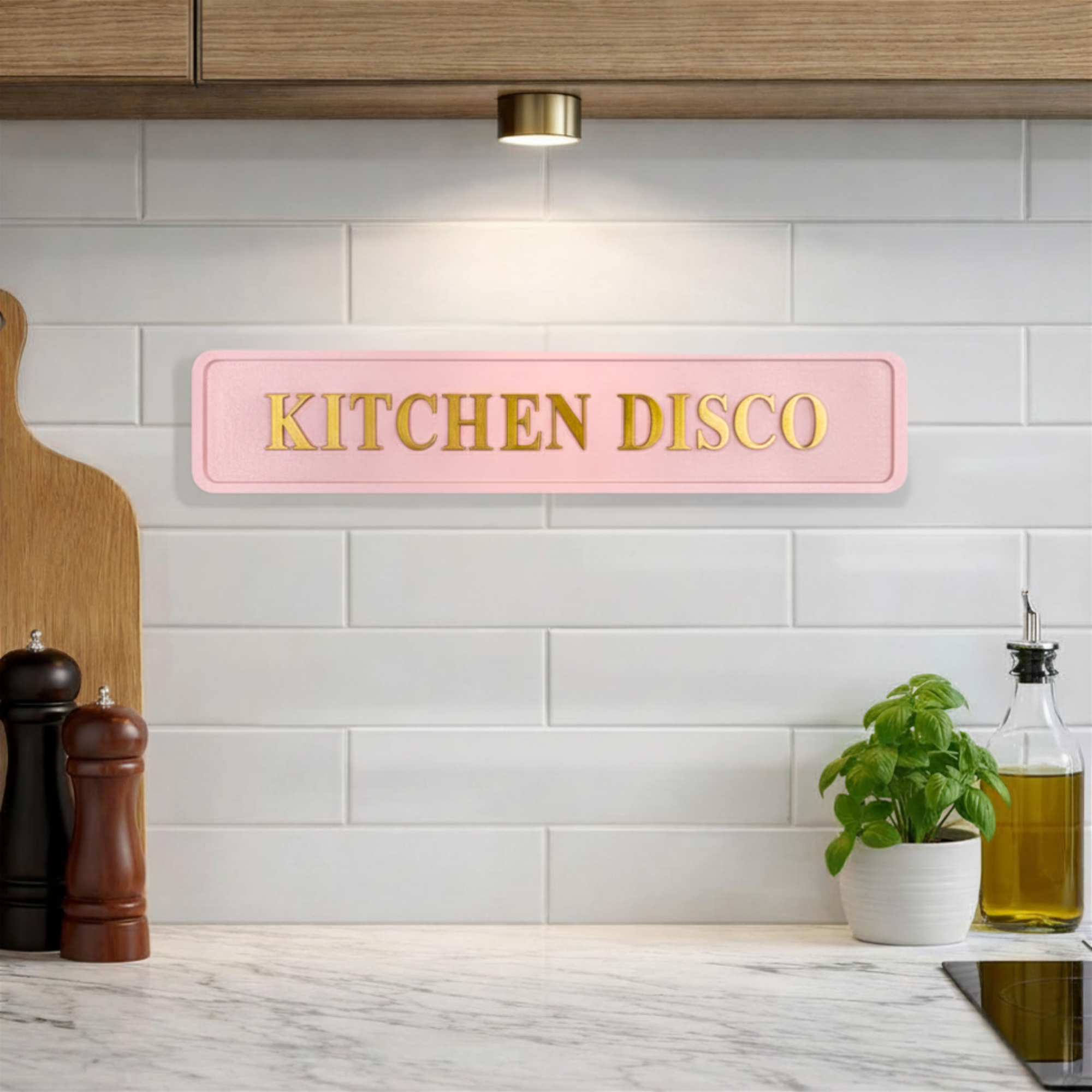 Pink decorative sign with KITCHEN DISCO gold text in a stylish kitchen setting