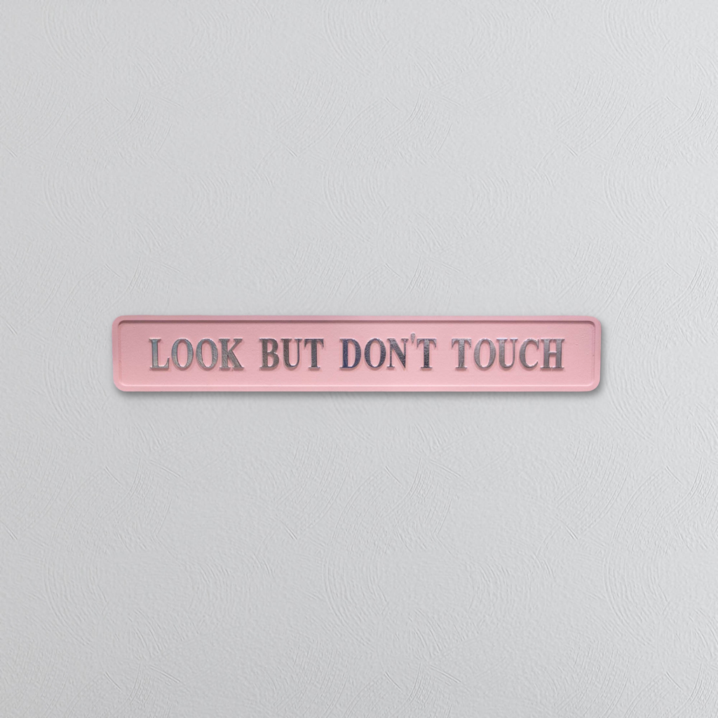 Pink sign with 'Look But Don't Touch' text on a light gray background