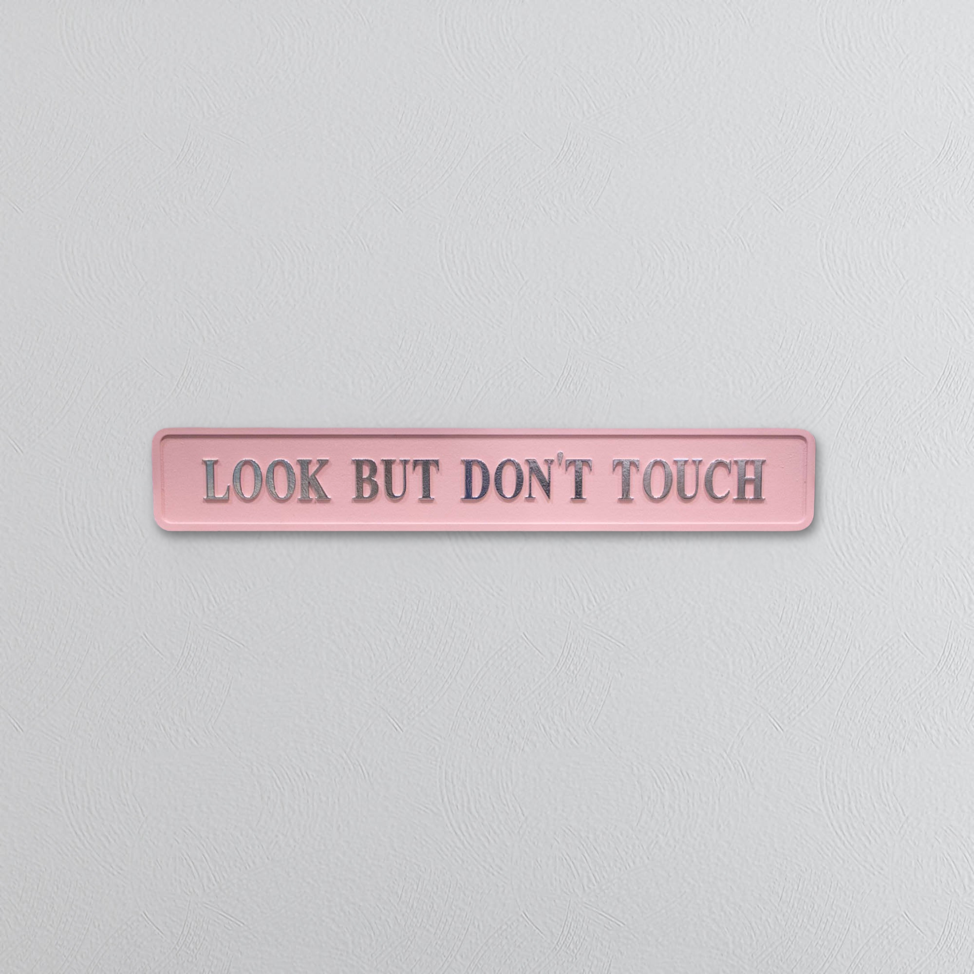Pink sign with 'Look But Don't Touch' text on a light gray background