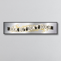 Decorative mirror sign with 'Look but don't touch' art deco style text on a gray background