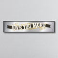 Decorative mirror sign with 'I love you more' art deco style text on a plain background