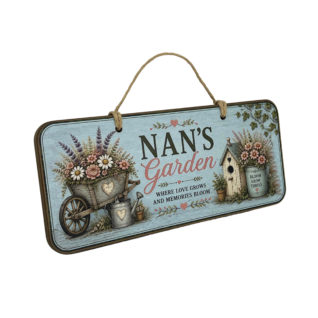 A rectangular hanging wooden sign with a rustic design for 'Nan's Garden'. The sign features a light blue weathered wood background with illustrations of a wheelbarrow filled with flowers, a watering can, a birdhouse, and a small bee.
