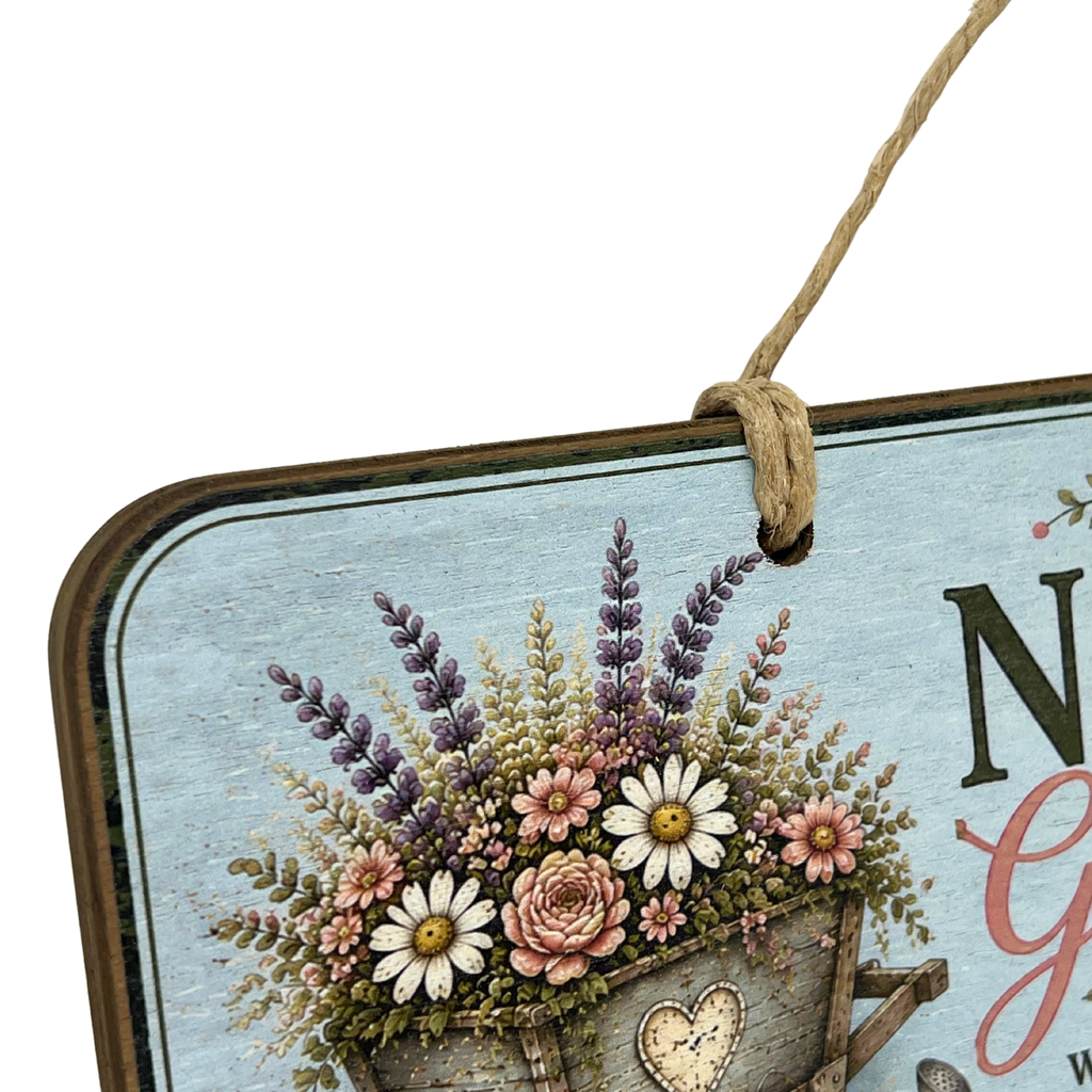 A decorative hanging sign with a rustic wood-look border, a light blue background, and a floral arrangement in a bucket. The sign includes partial lettering and is suspended by a rope hanger against a plain white background.