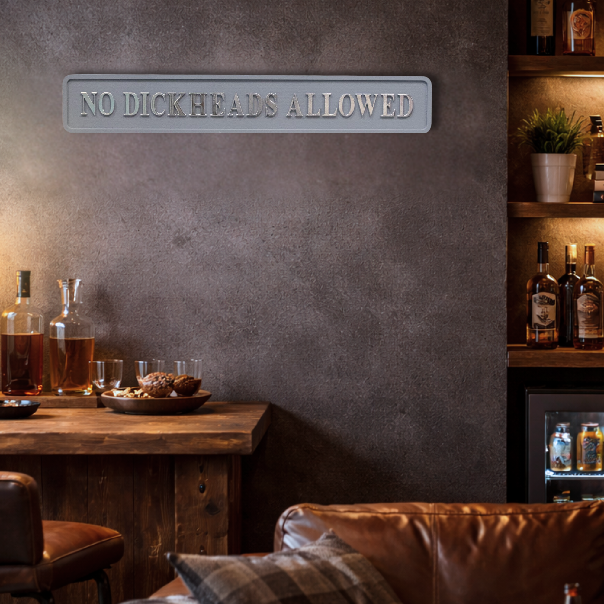 Bar area with 'No Dickheads Allowed' grey and silver sign on a gray wall.