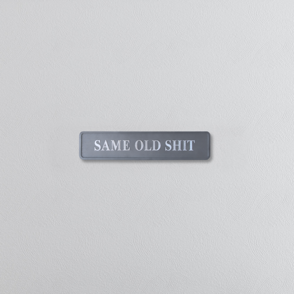 Gray wall with a rectangular sign reading 'SAME OLD SHIT'