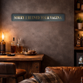 Man cave with a bar setup, including bottles and glasses, with a humorous sign reading 'SORRY I RUINED YOUR VAGINA' on the wall.