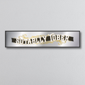 Decorative mirror sign with 'Sotally Tober' art deco style text on a grey background