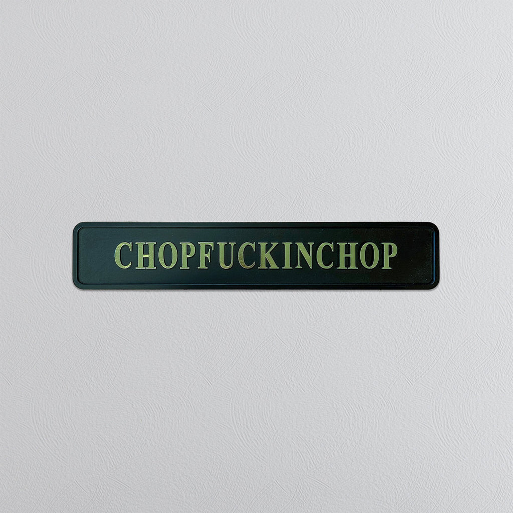 Rectangular sign with gold foil text 'CHOPFUCKINCHOP' on a light gray background