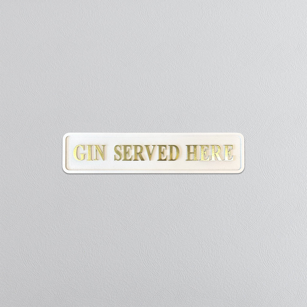 Cream sign with 'GIN SERVED HERE' gold text on a gray background