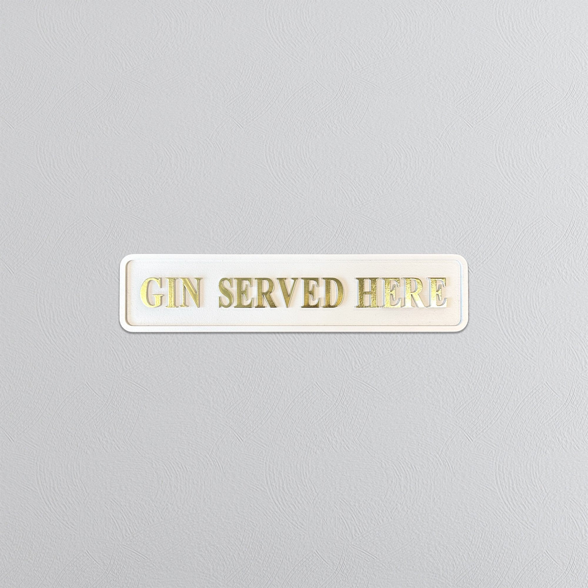 Cream sign with 'GIN SERVED HERE' gold text on a gray background