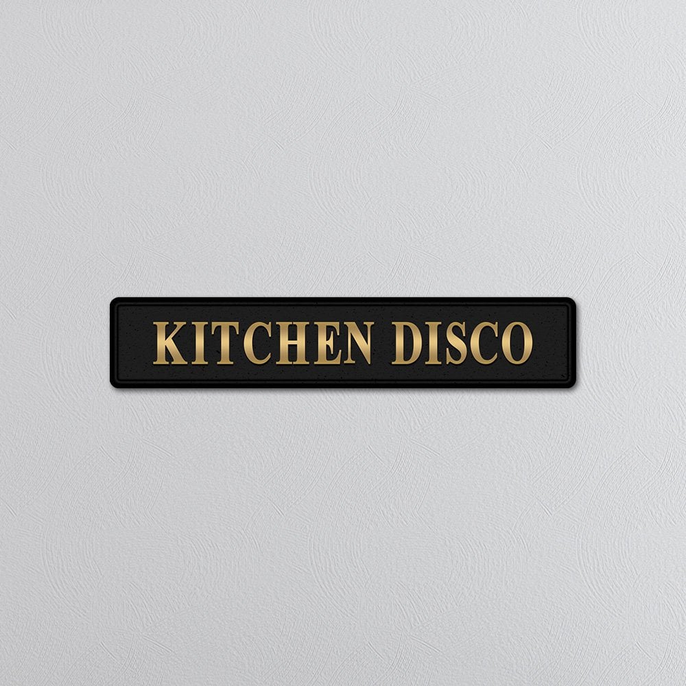 Decorative sign with 'KITCHEN DISCO' gold text on a light gray background