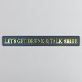 Decorative sign with gold text reading 'LETS GET DRUNK & TALK SHITE' on a gray background