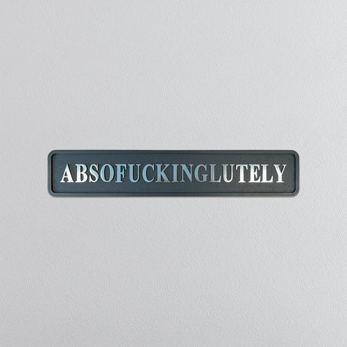 Decorative sign with the word 'ABSOFUCKINGGLUTELY' in silver foil on a gray background