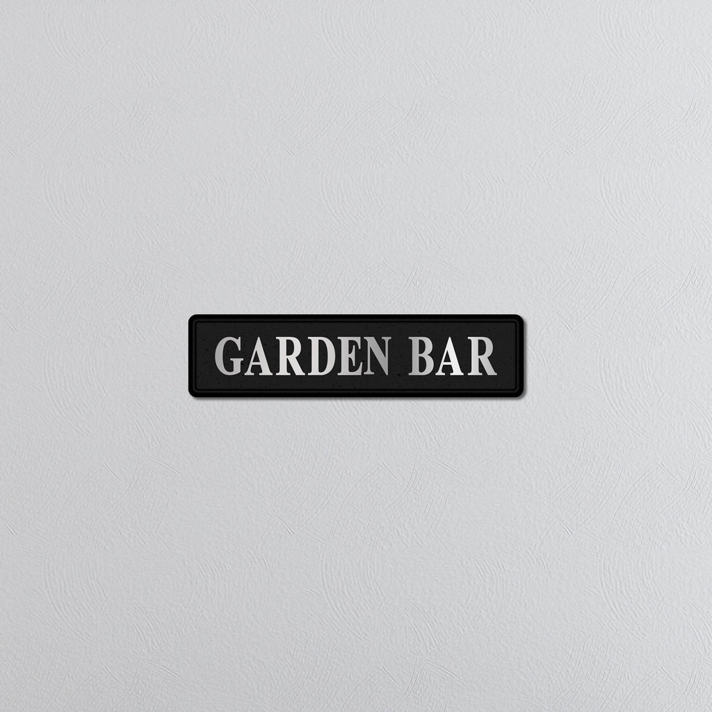 Black sign with 'GARDEN BAR' silver text on a light gray background