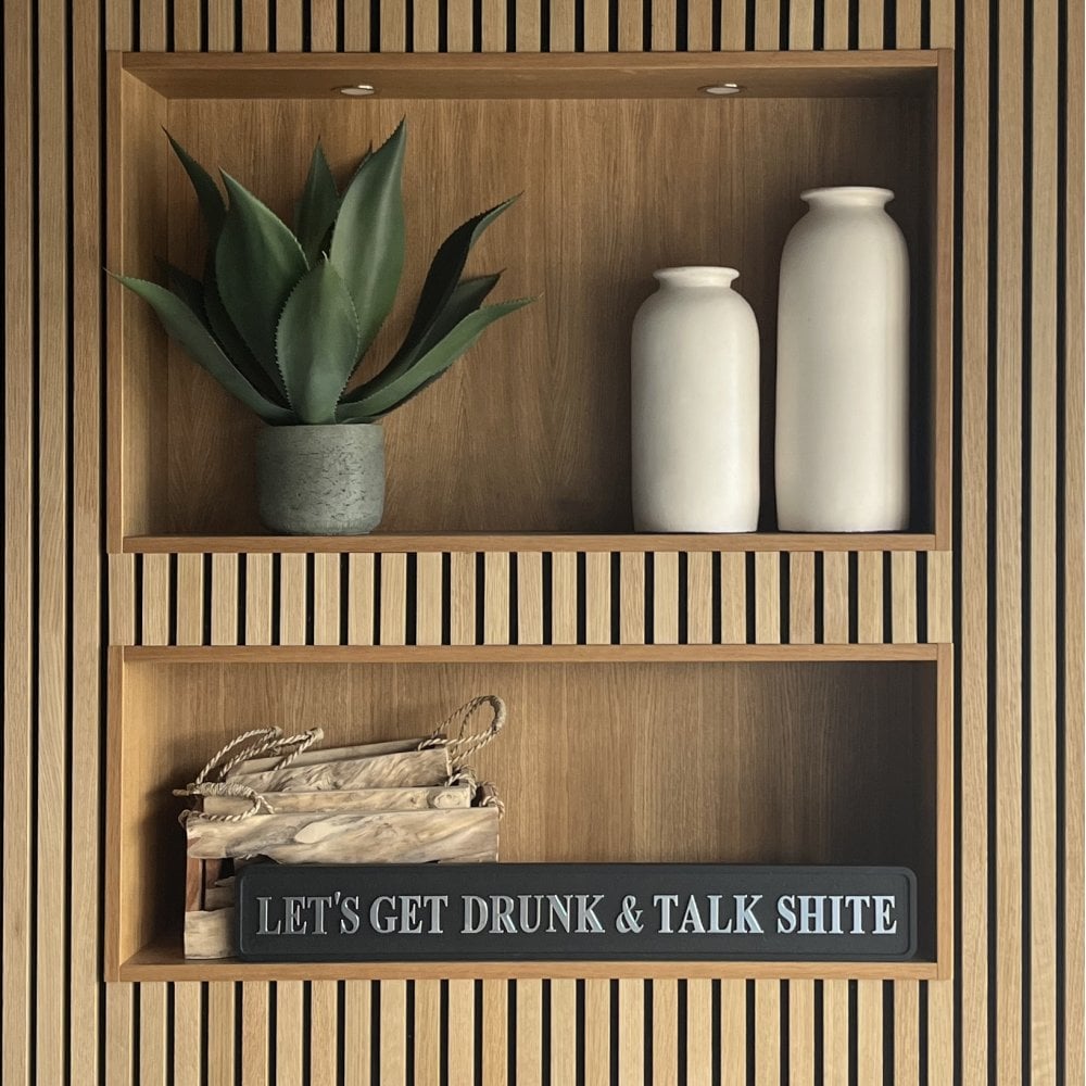 Wooden shelf with decorative items and a humorous sign saying LET'S GET DRUNK & TALK SHITE with silver text.