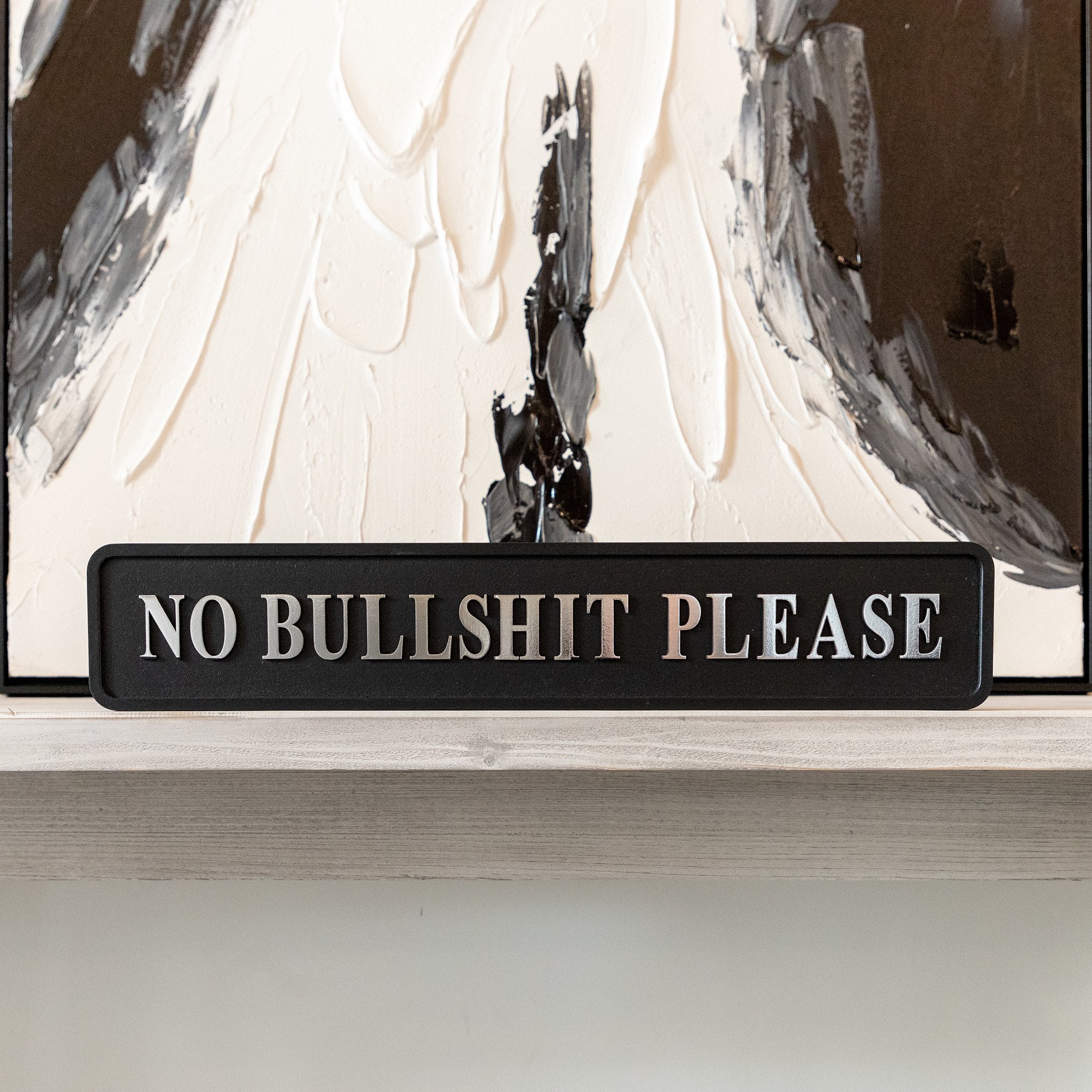 Black and silver foiled street sign with 'No bullshit please' wording