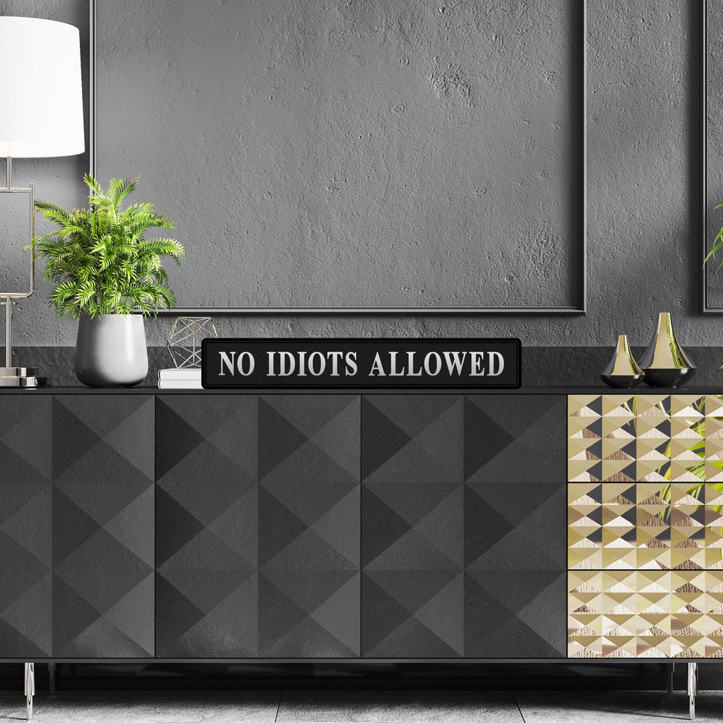 Black and silver foiled street sign with 'No idiots allowed' wording