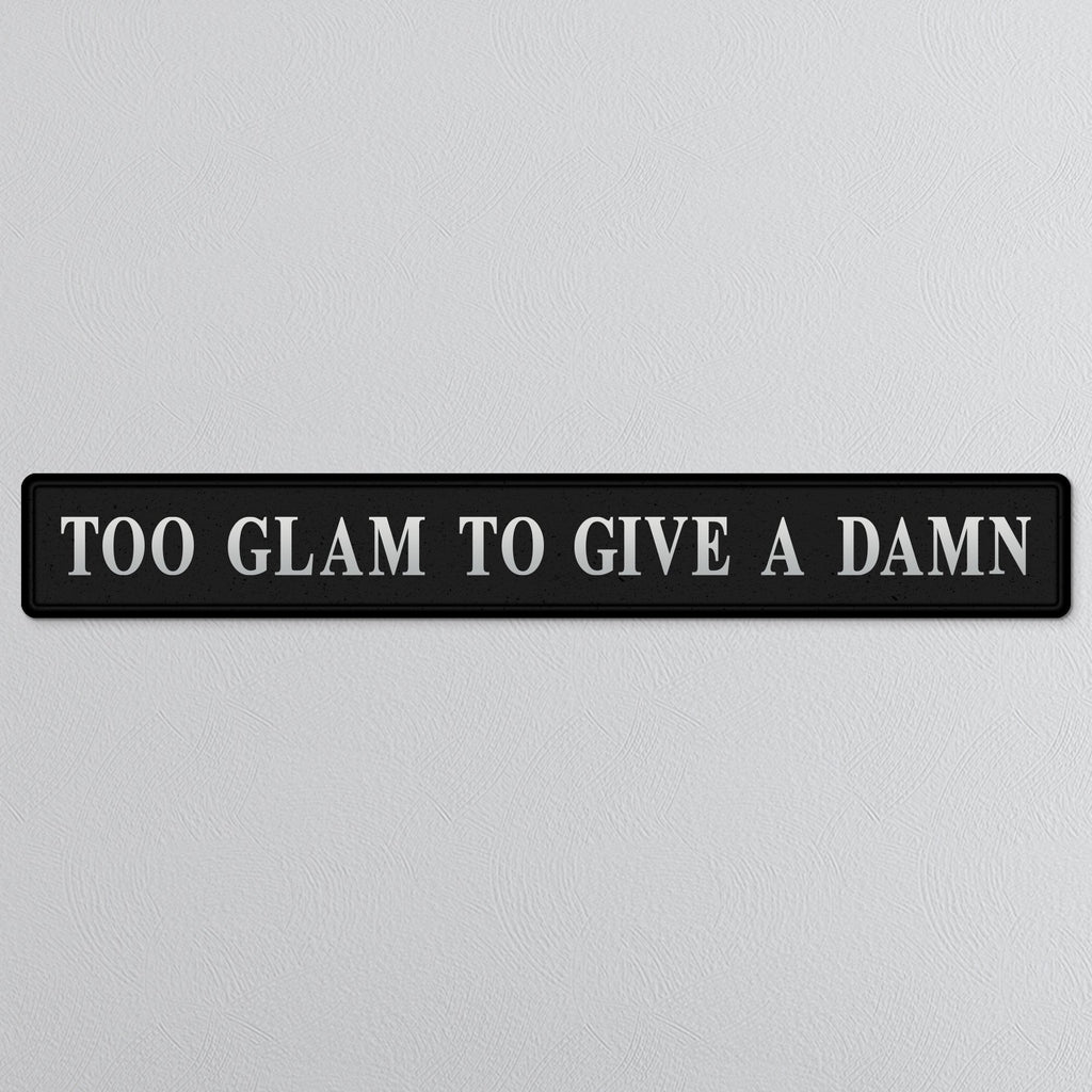 Black and silver foiled street sign with 'Too glam to give a damn' wording