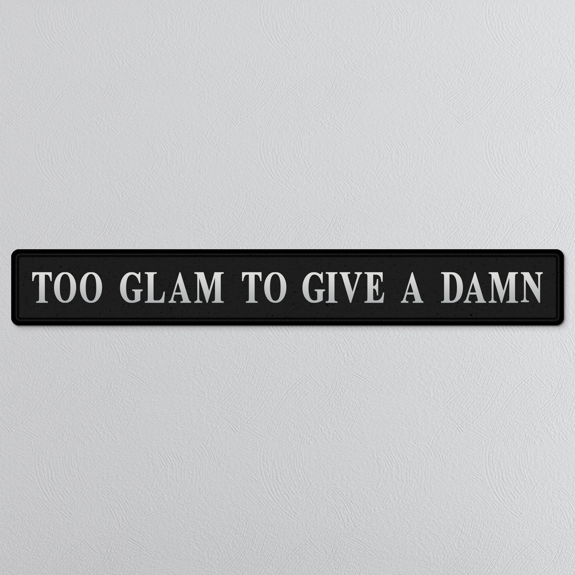 Black and silver foiled street sign with 'Too glam to give a damn' wording
