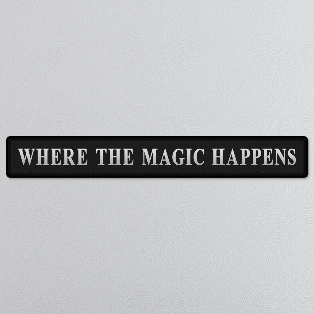 Black and silver foiled street sign with 'Where the magic happens' wording