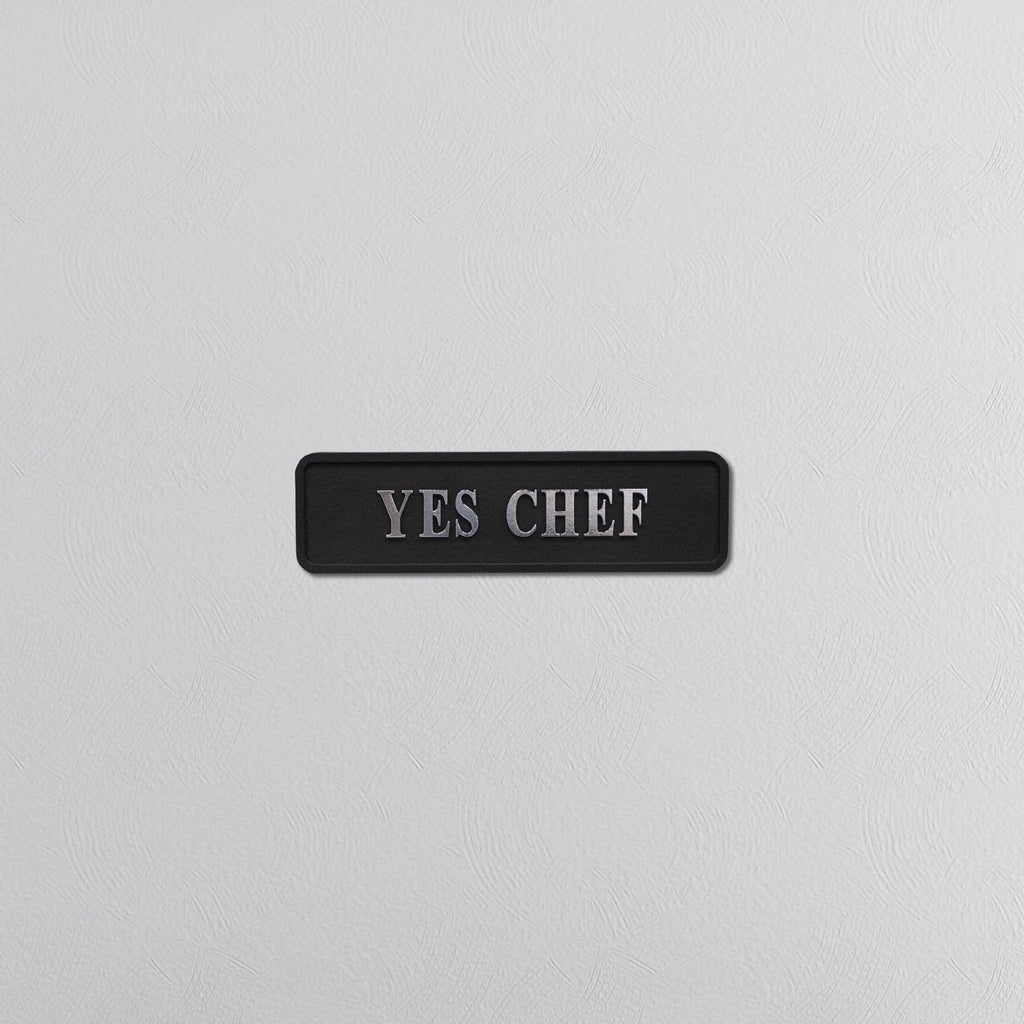 Black decorative sign with silver text YES CHEF