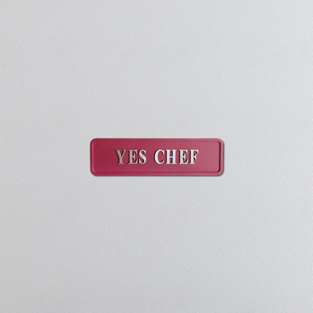 Decorative red sign with silver text reading YES CHEF