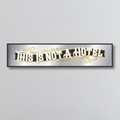 Decorative mirror sign with 'This is not a hotel' art deco style text on a light gray background