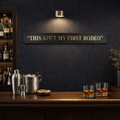 Bar setting with 'This Ain't My First Rodeo' sign, drinks, and bar equipment.