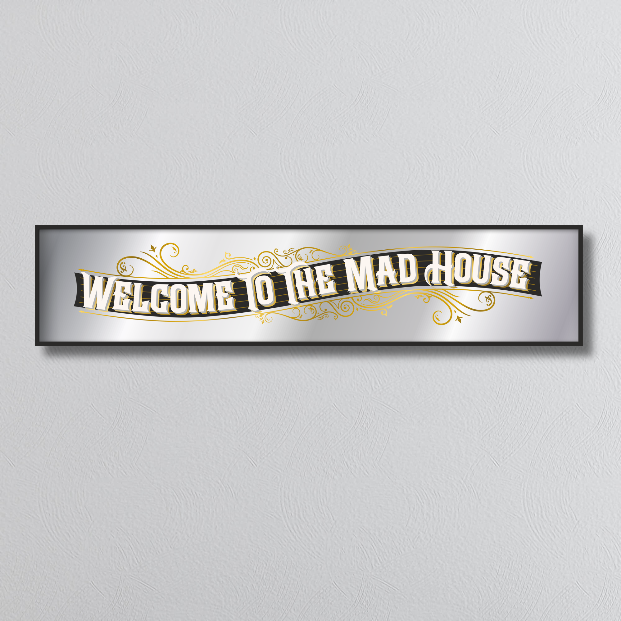 Decorative mirror sign with 'Welcome to the Mad House' art deco style text on a plain background