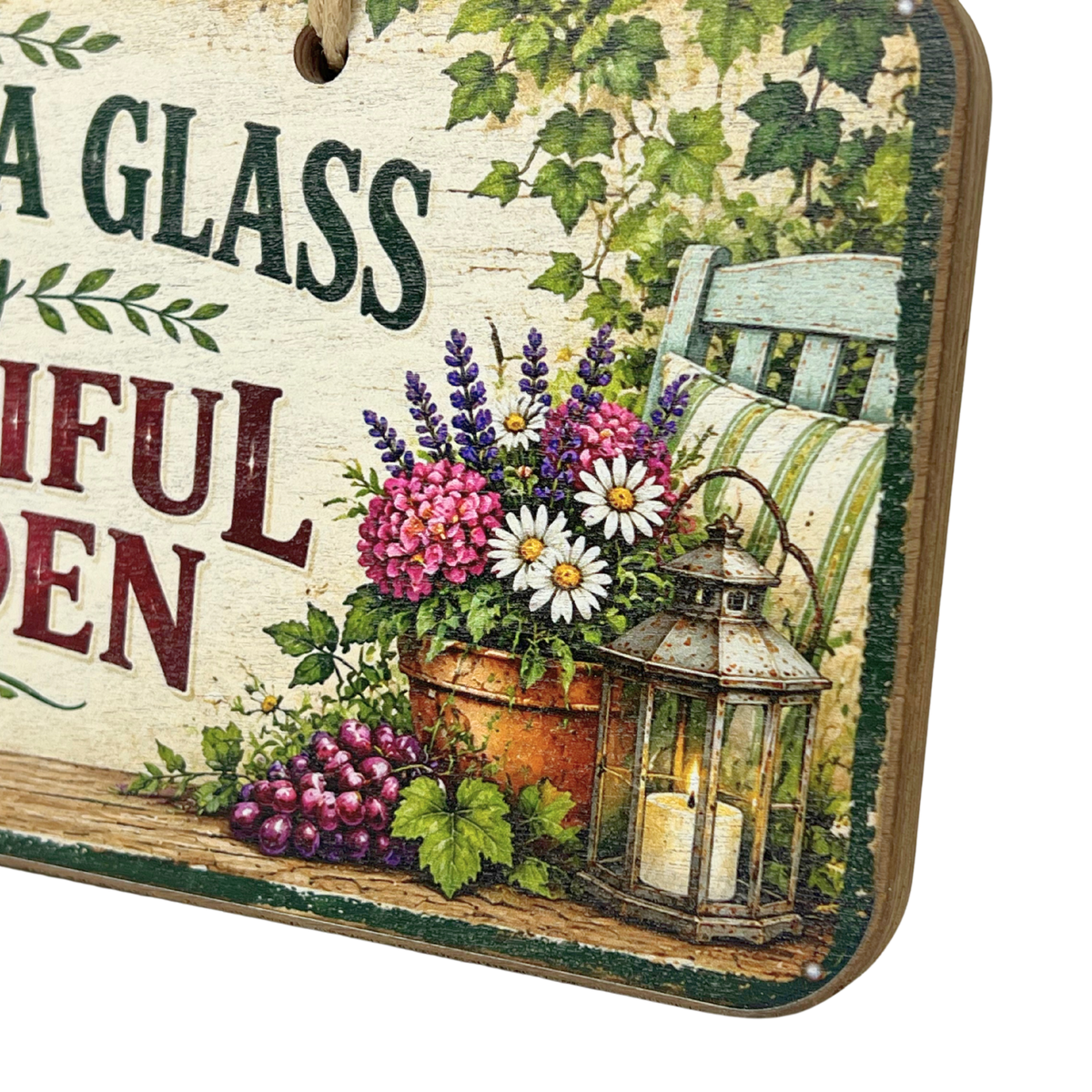A decorative square sign with rounded corners featuring a rustic garden scene. The sign shows partial text reading 'A GLASS' and 'FUL GARDEN' over a cream background, with illustrated flowers, a potted plant, a lantern, grapes, ivy, and a striped chair.