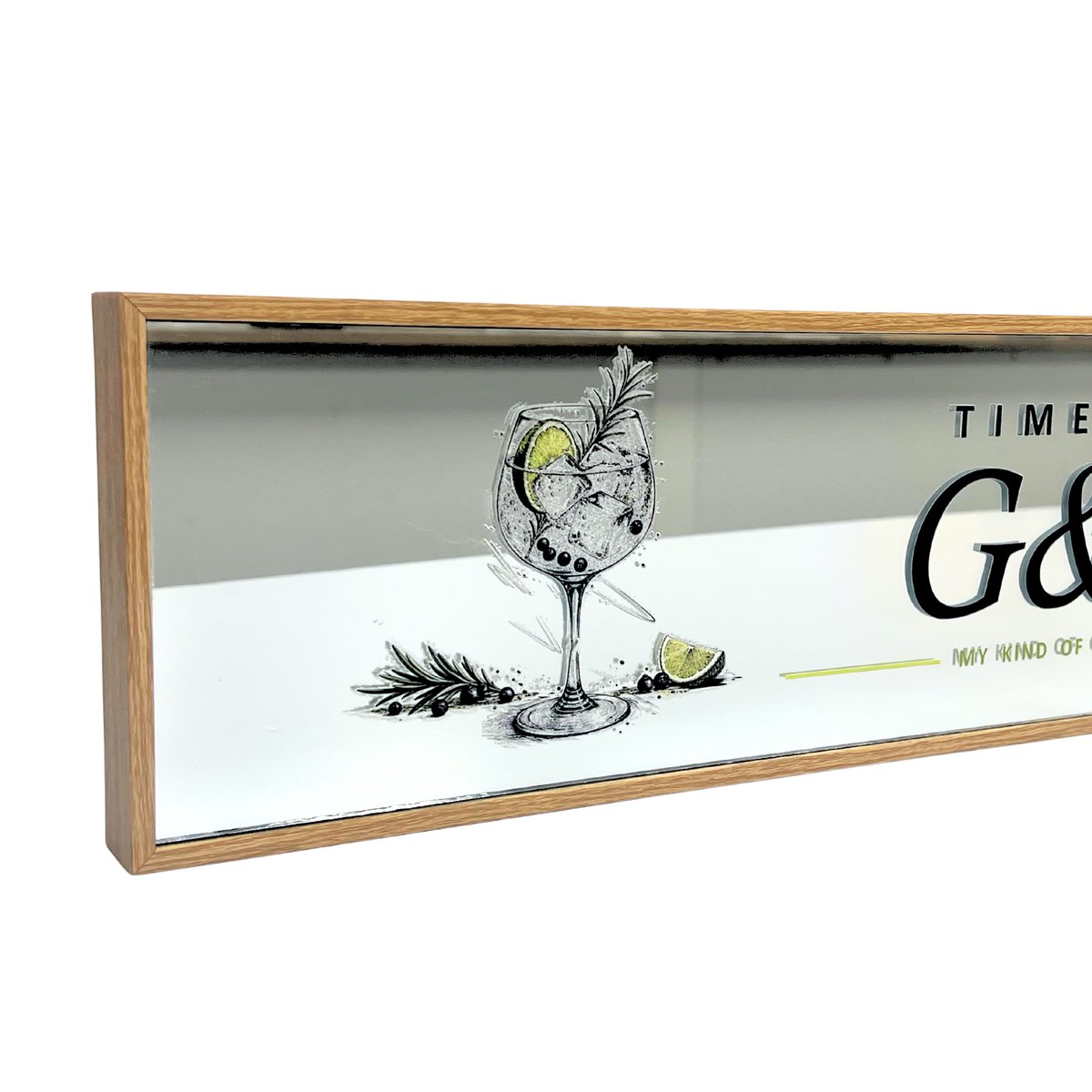 A rectangular framed wall sign with a light natural wood frame and mirrored glass. The reflection shows a bar counter, while the sign face features a black and white sketch of a cocktail glass with a lime wedge and botanical garnish, alongside partial black text reading 'TIME G.