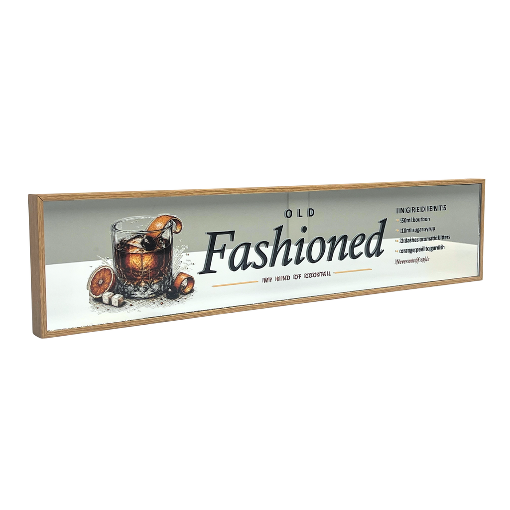 A rectangular framed wall sign with a light wood frame and a white background, featuring the words 'Old Fashioned' in large black script, a glass of amber cocktail with orange slices, and small ingredient text on the right side.